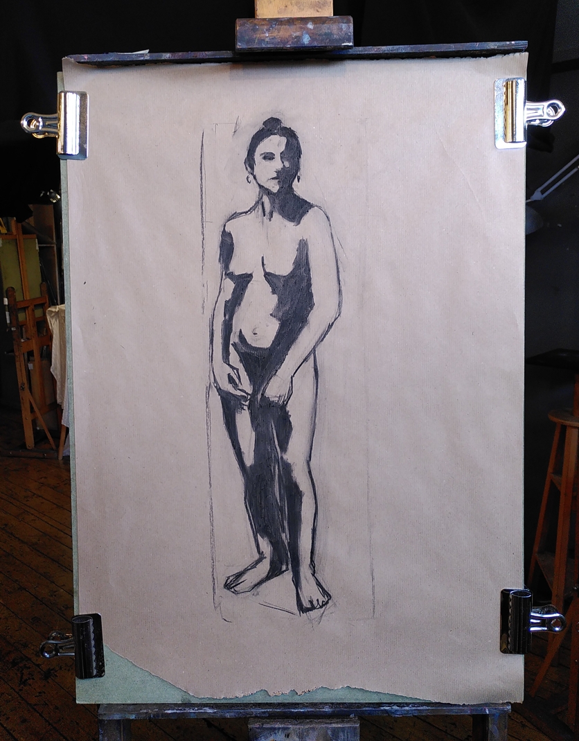 Charcoal drawing on brown packing paper of a figure with hard-edged shadow shapes.