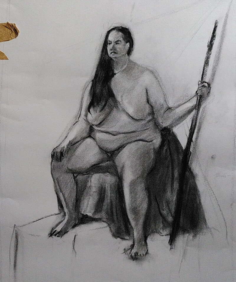 A woman with long dark hair and lots of body-fat, sitting confidently and holding a pole.