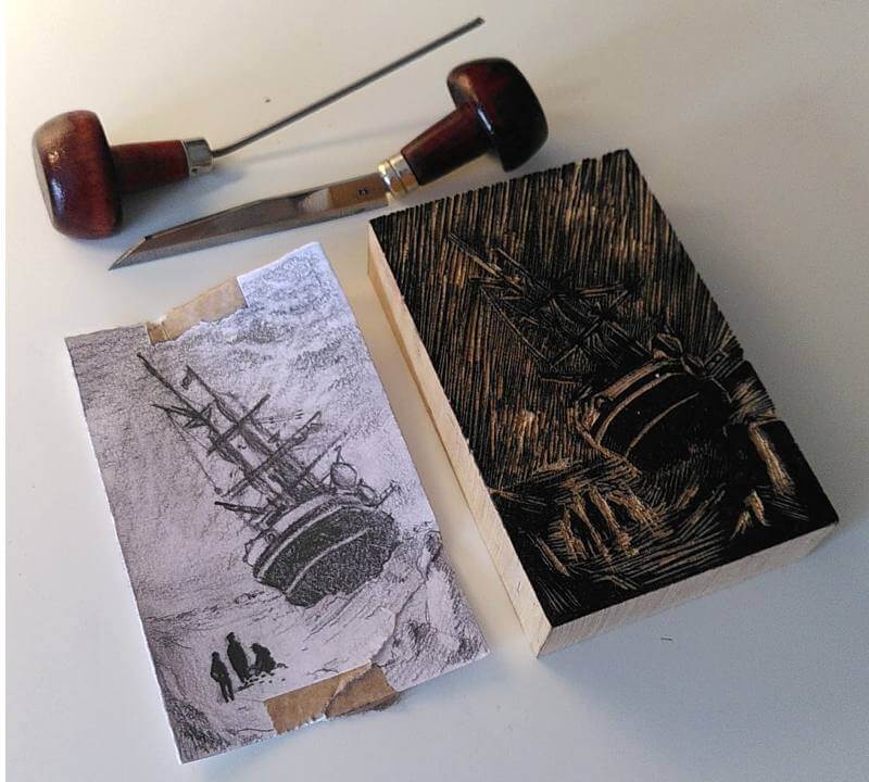 A pencil sketch of the ship design, two engraving tools, and the engraved wood block, blackened by ink.