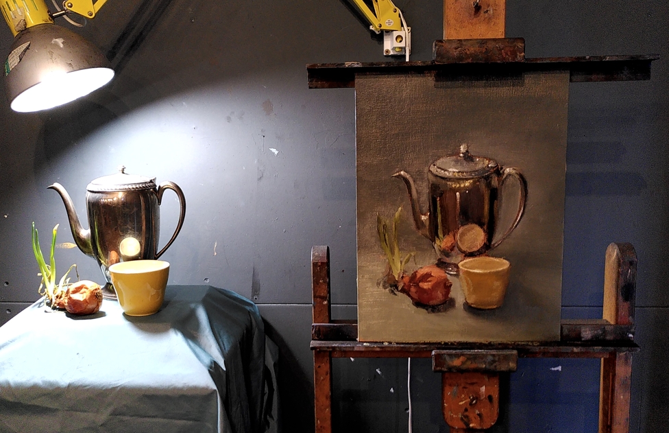 Full-colour oil painting of a still life scene, beside the real thing; a tall chrome teapot sitting behind a yellow cup and a brown onion with long green sprouts.
