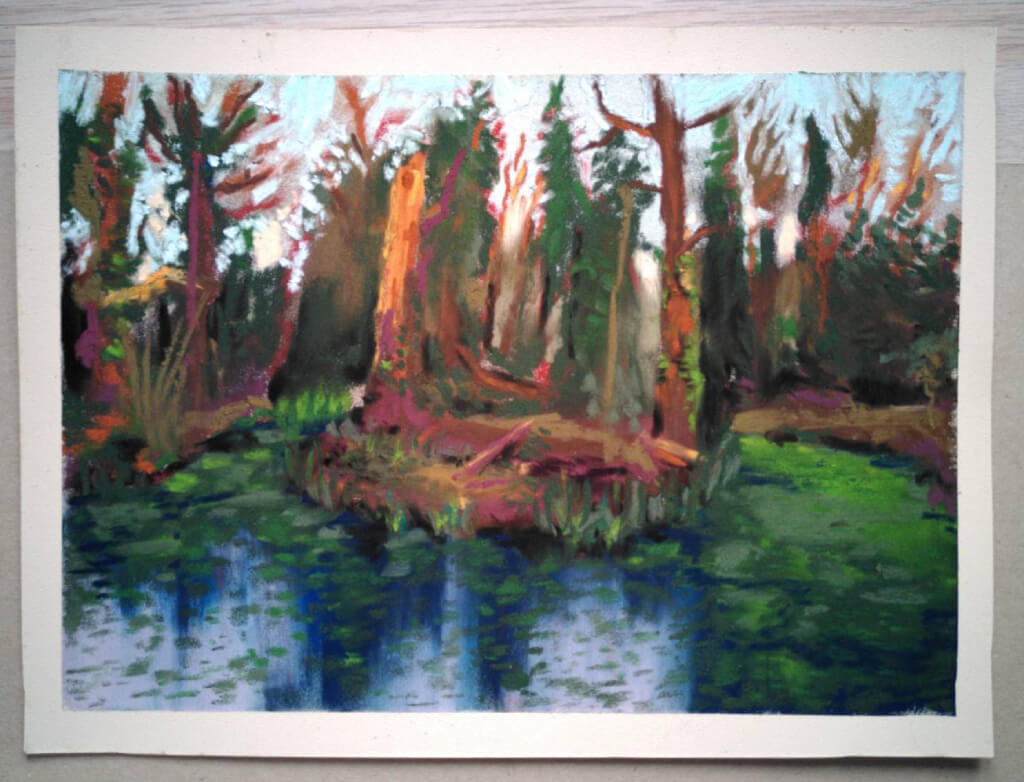 Colour pastel drawing of a late-afternoon woodland pond. Broken trunks emerge from a small central island.