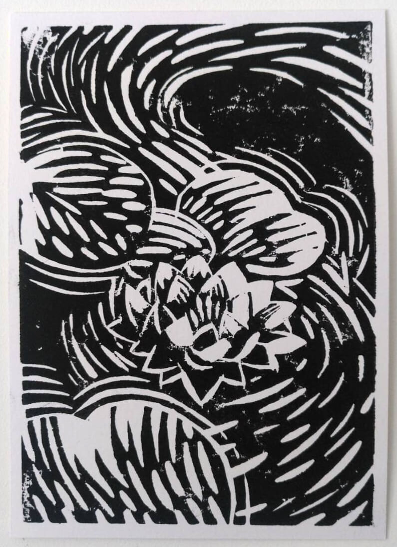 Stylised black and white woodcut print of a waterlily in a pond, surrounded by lilypads.